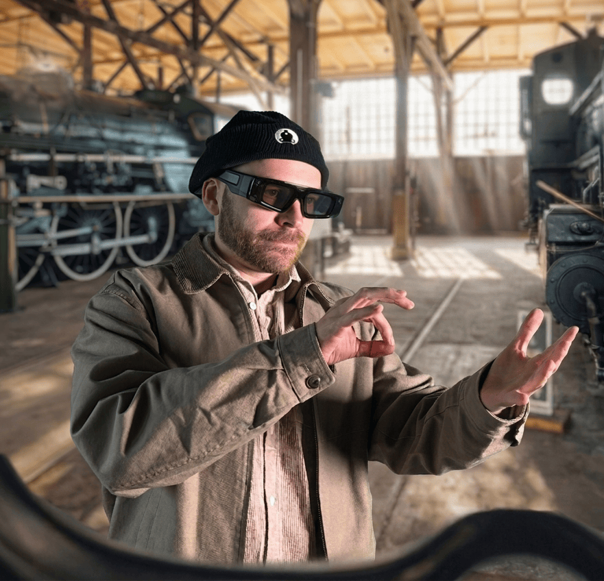 Gonzalo Orce wearing AR glasses among historic locomotives